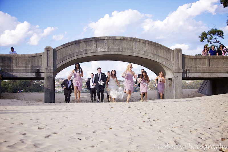 Bridal party running under the bridge at Balmoral Beach - wedding photography sydney